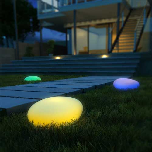 Multi-Colored Large Stone-Shaped Solar Globe Lights at Night in Backyard